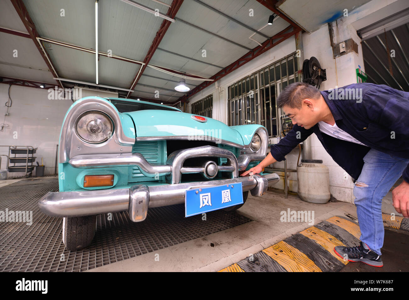 The owner of the 59-year-old "Phoenix" vintage car cleans the sedan