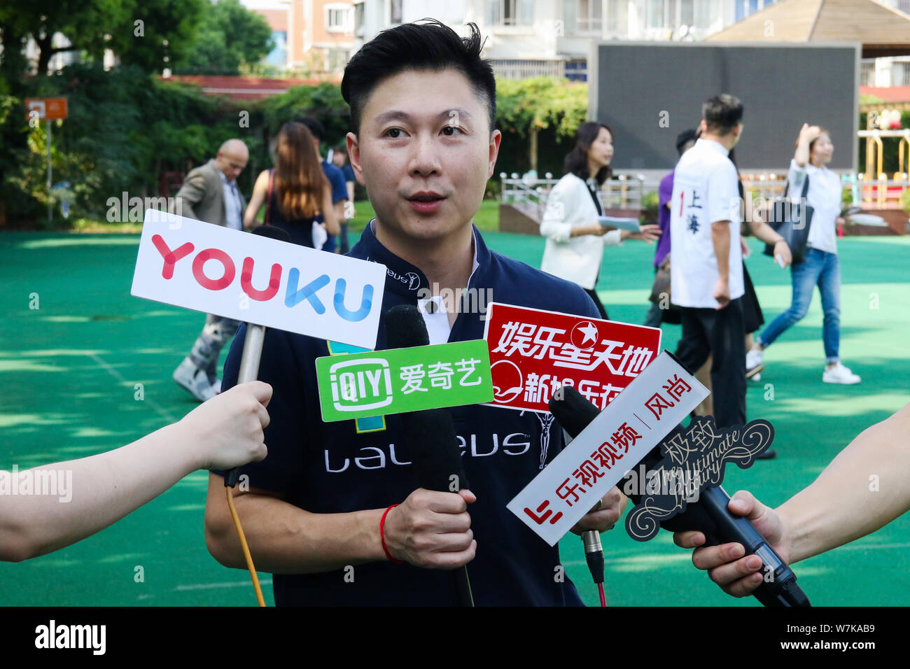 Former Chinese Olympic gymnastics chapion Li Xiaopeng receives an interview during the IWC Awards Ceremony for children's painting competition in Shan Stock Photo