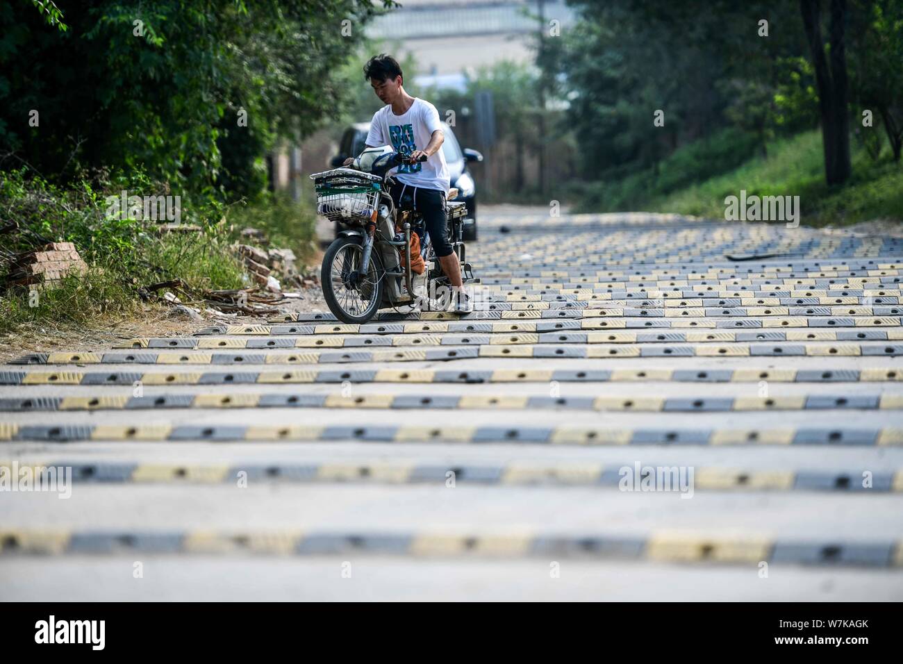 A cyclist rides on a 200meterlong "washboard road" with more than 100 speed bumps in Fengtai