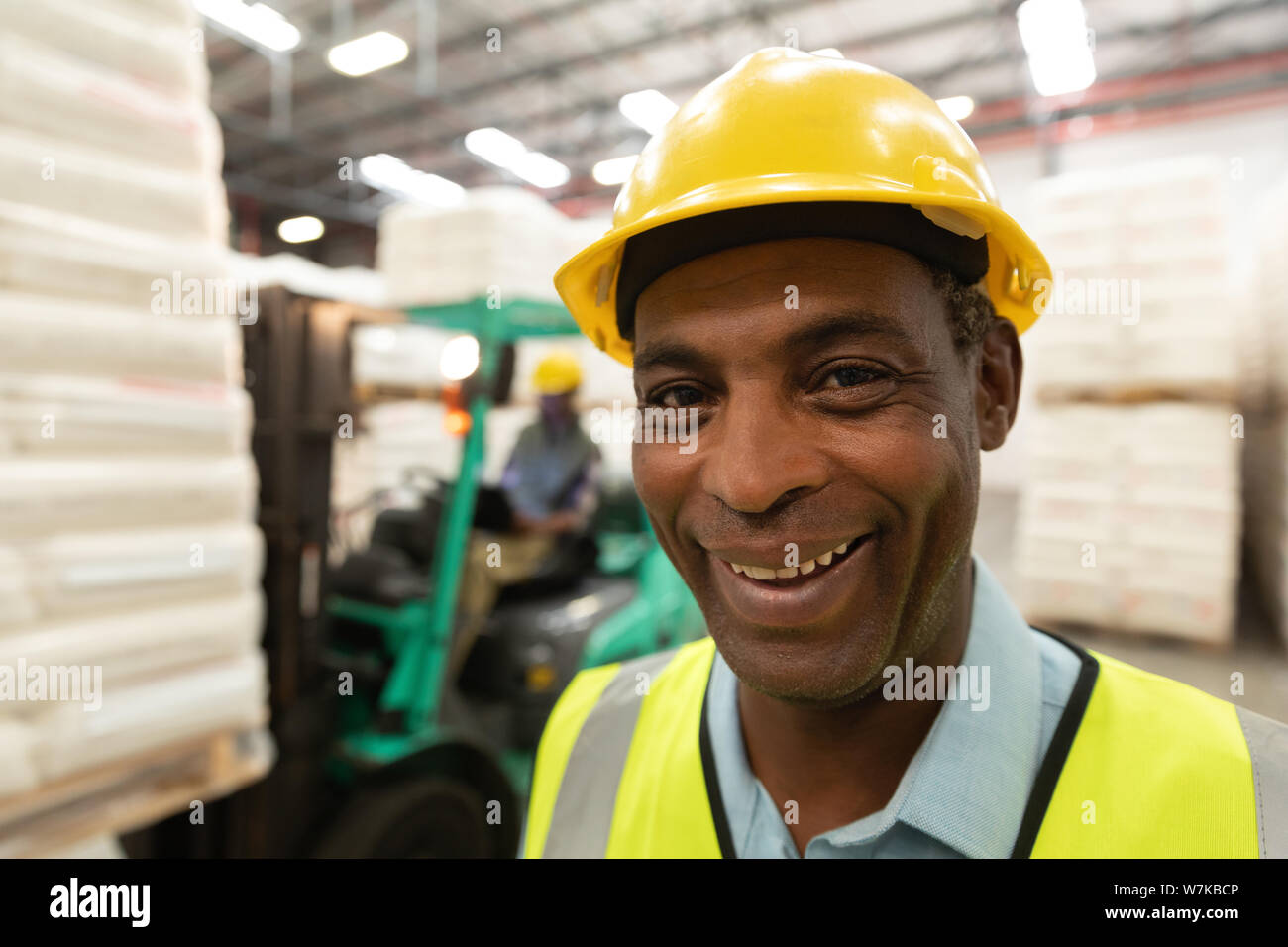 Happy male worker looking at camera in warehouse Stock Photo