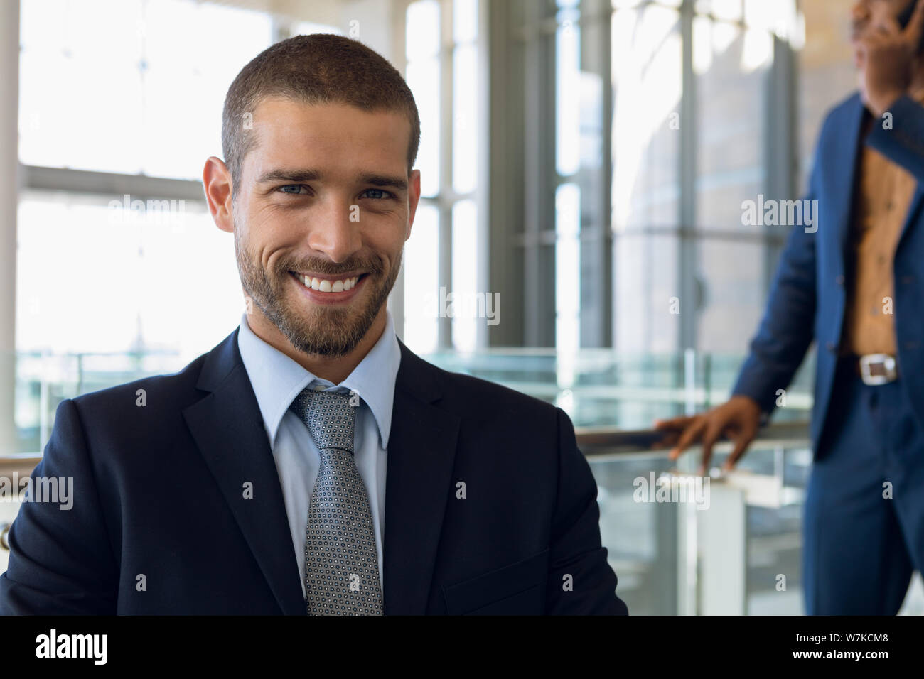 Young businessman sitting in an office smiling to camera Stock Photo
