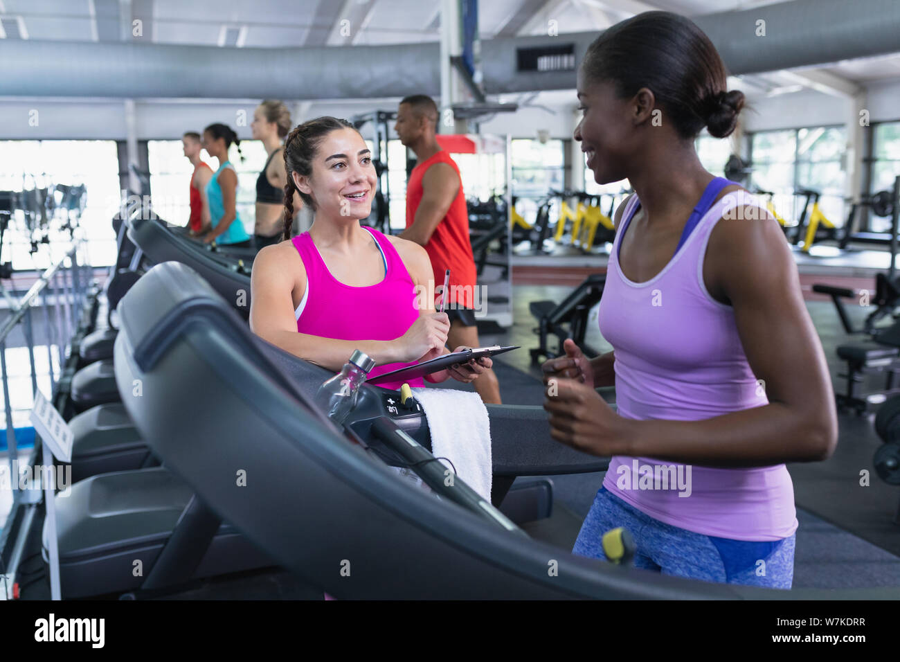 Female trainer interacting with woman in fitness center Stock Photo