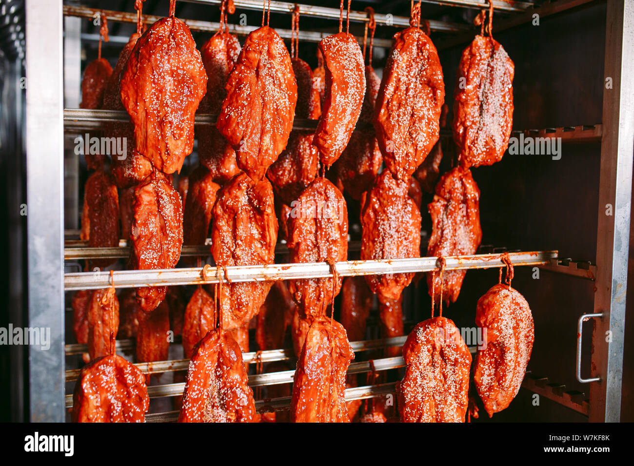 Smoked ham in the oven. Sausage production in the factory Stock Photo