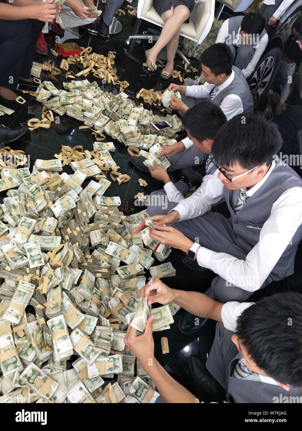 Chinese employees count massive one-yuan banknotes paid by a shop owner as down payment to buy a Guangqi-Honda vehicle at a dealership in Binzhou city Stock Photo