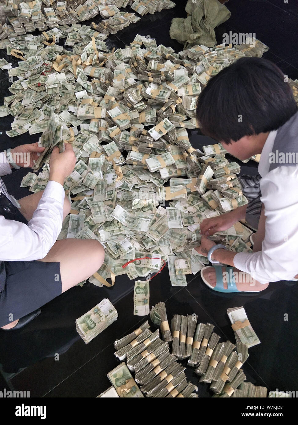 Chinese employees count massive one-yuan banknotes paid by a shop owner as down payment to buy a Guangqi-Honda vehicle at a dealership in Binzhou city Stock Photo