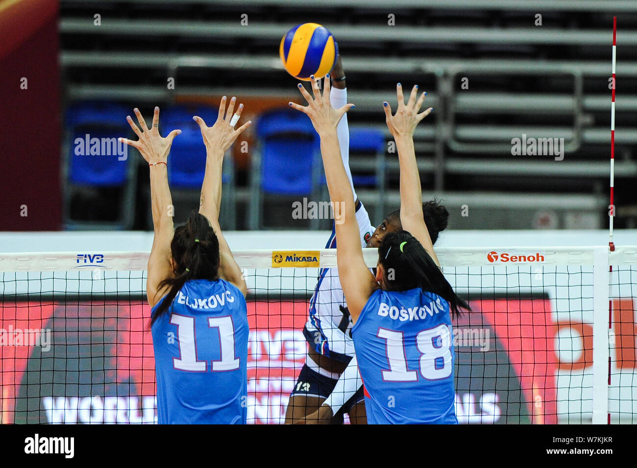 Stefana Veljkovic, left, and Tijana Boskovic of Serbia spike against Miryam Fatime Sylla of Italy during their match of the FIVB Volleyball World Gran Stock Photo