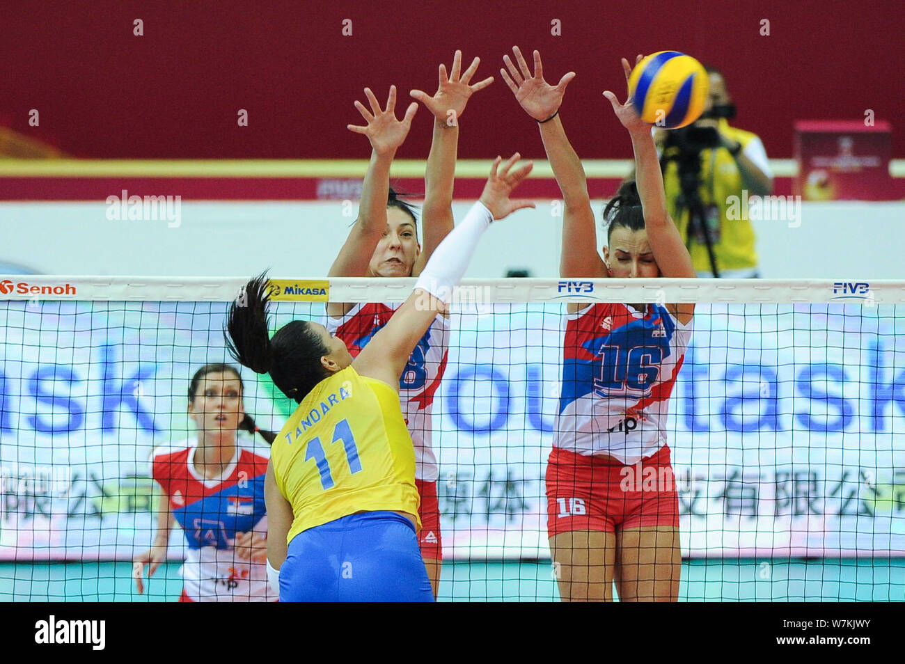 Tandara Caixeta of Brazil spikes against Tijana Boskovic and Milena Rasic of Serbia during their match of the FIVB Volleyball World Grand Prix Finals Stock Photo