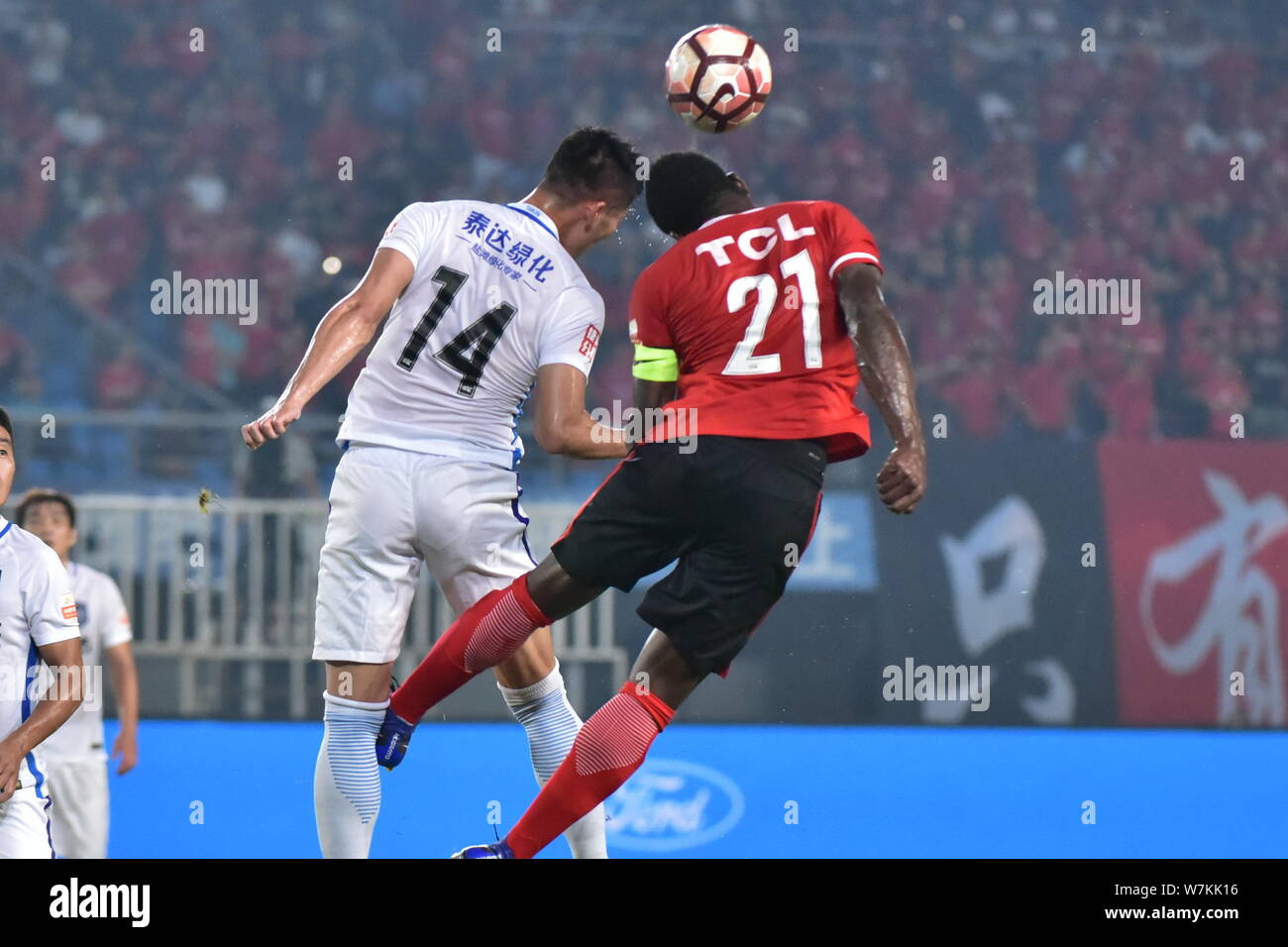 Cameroonian football player Christian Bekamenga, right, of Liaoning Whowin, heads the ball against South Korean football player Hwang Seok-ho of Tianj Stock Photo