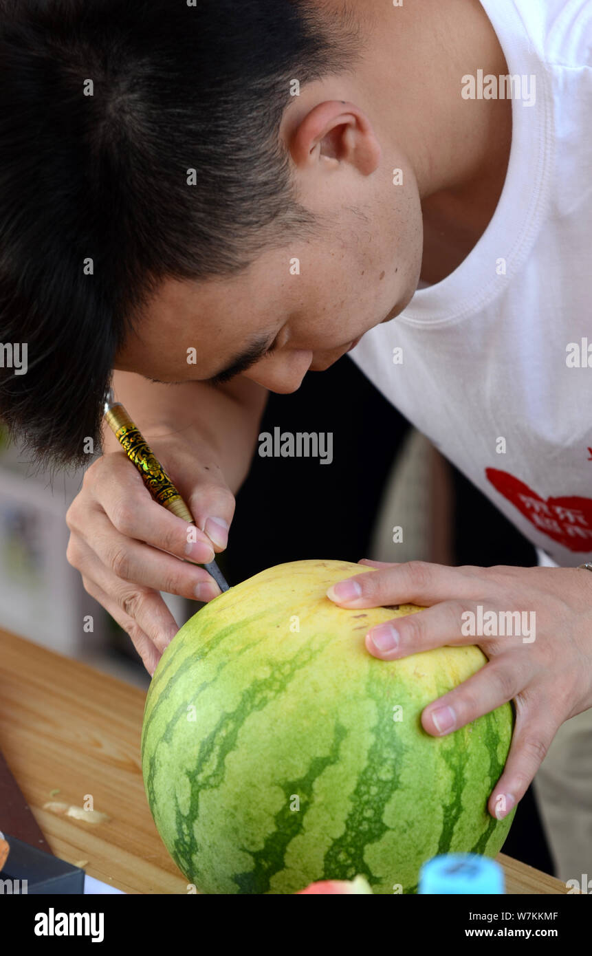 Chinese post-80's man Guan Yunlong creates a watermelon carving in Xuchang city, central China's Henan province, 13 August 2017.   Chinese post-80's m Stock Photo