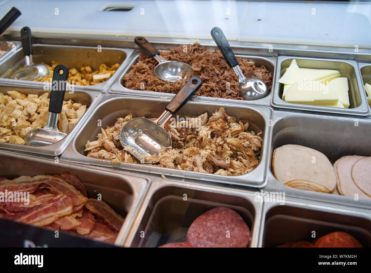 Various types of meats, cold cuts, and cheese at a sub sandwich eatery
