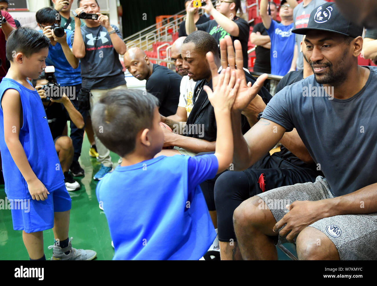 NBA star Metta World Peace, right, interacts with a younger player