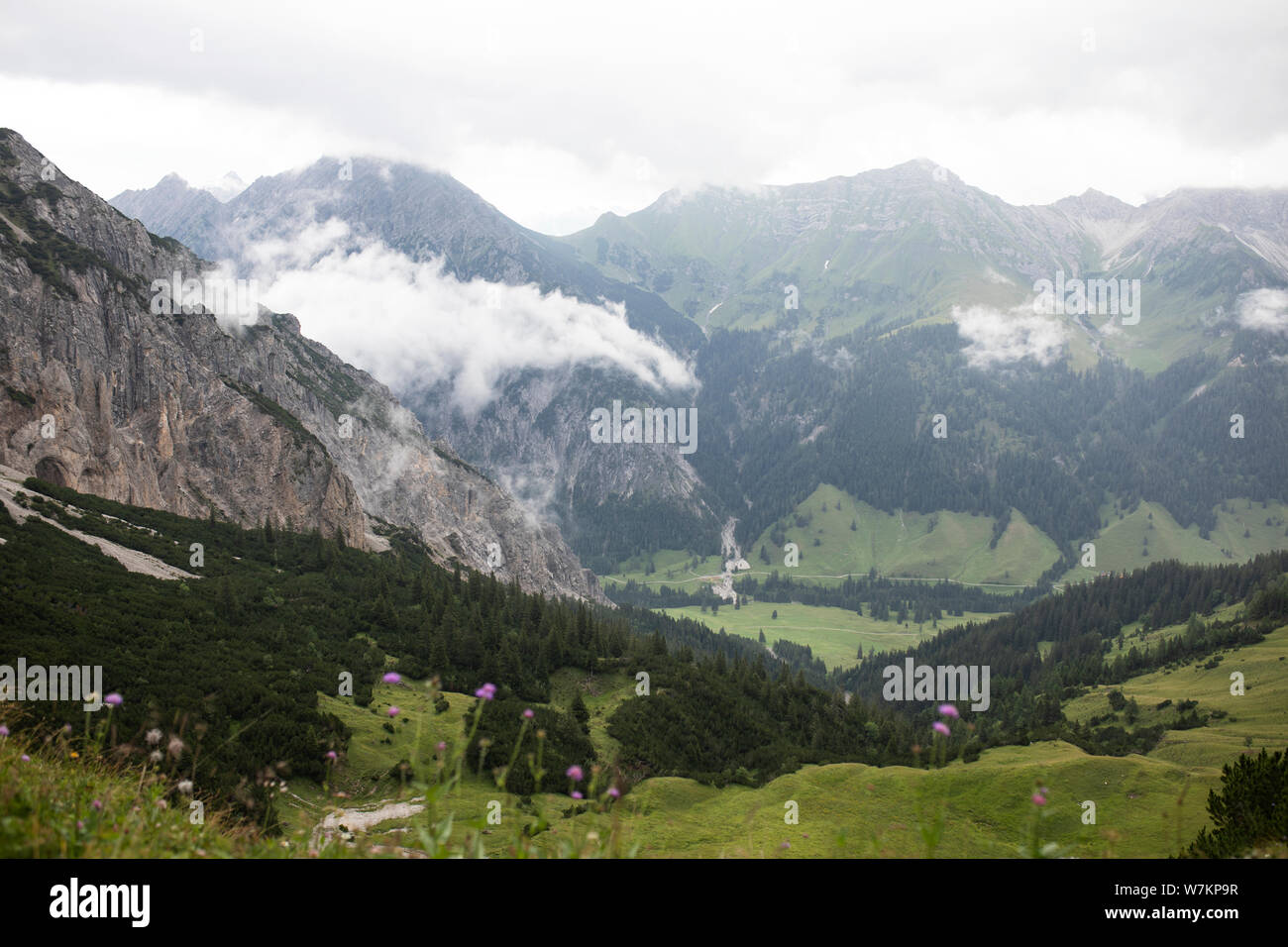 Fog rolls in on a cloudy and rainy day in the Alps near Malbun, Liechtenstein, with views from the Sareis gondola station overlooking the valley. Stock Photo