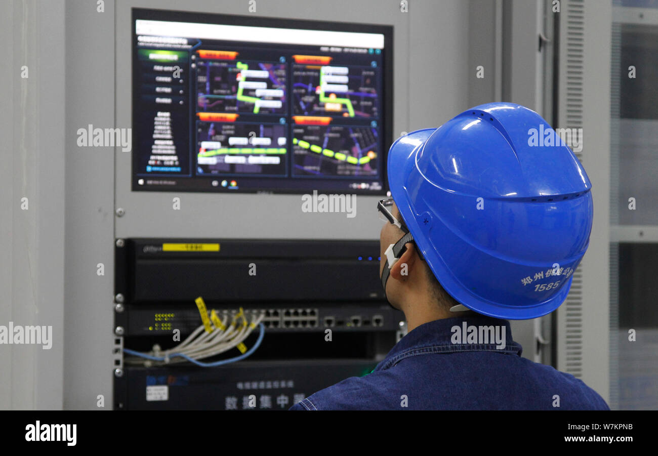 A Chinese worker checks a screen as a smart robot conducts real-time ...