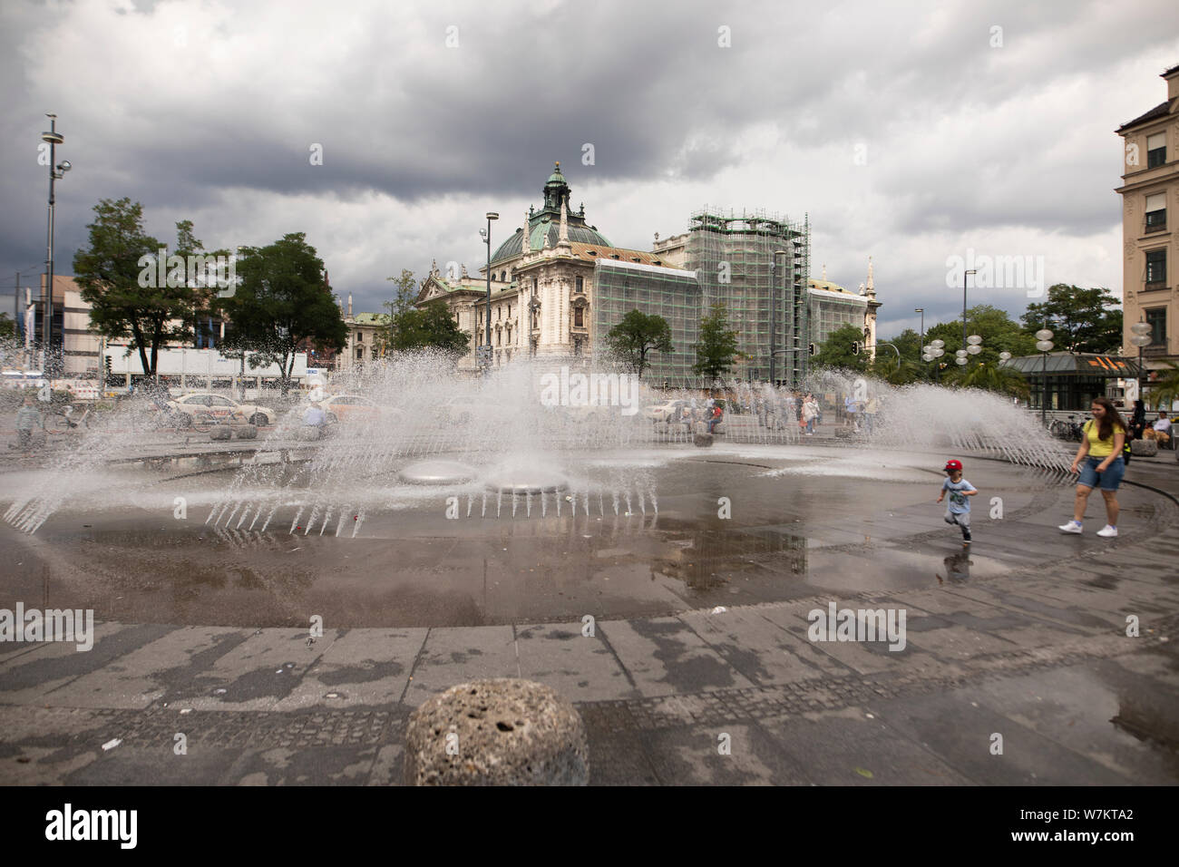 The fountain at Karlsplatz in Munich, Germany, on a cloudy summer day. The Munich District Court I building is in the background. Stock Photo