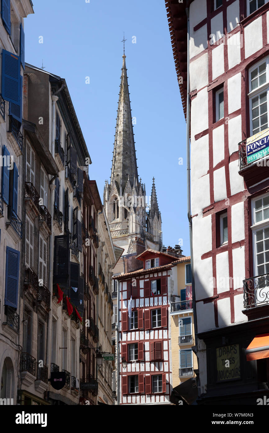 The view of one of the two steeples of the cathedral from the heart of the  old town of Bayonne (France). Au coeur de la vieille ville de Bayonne. Stock Photo
