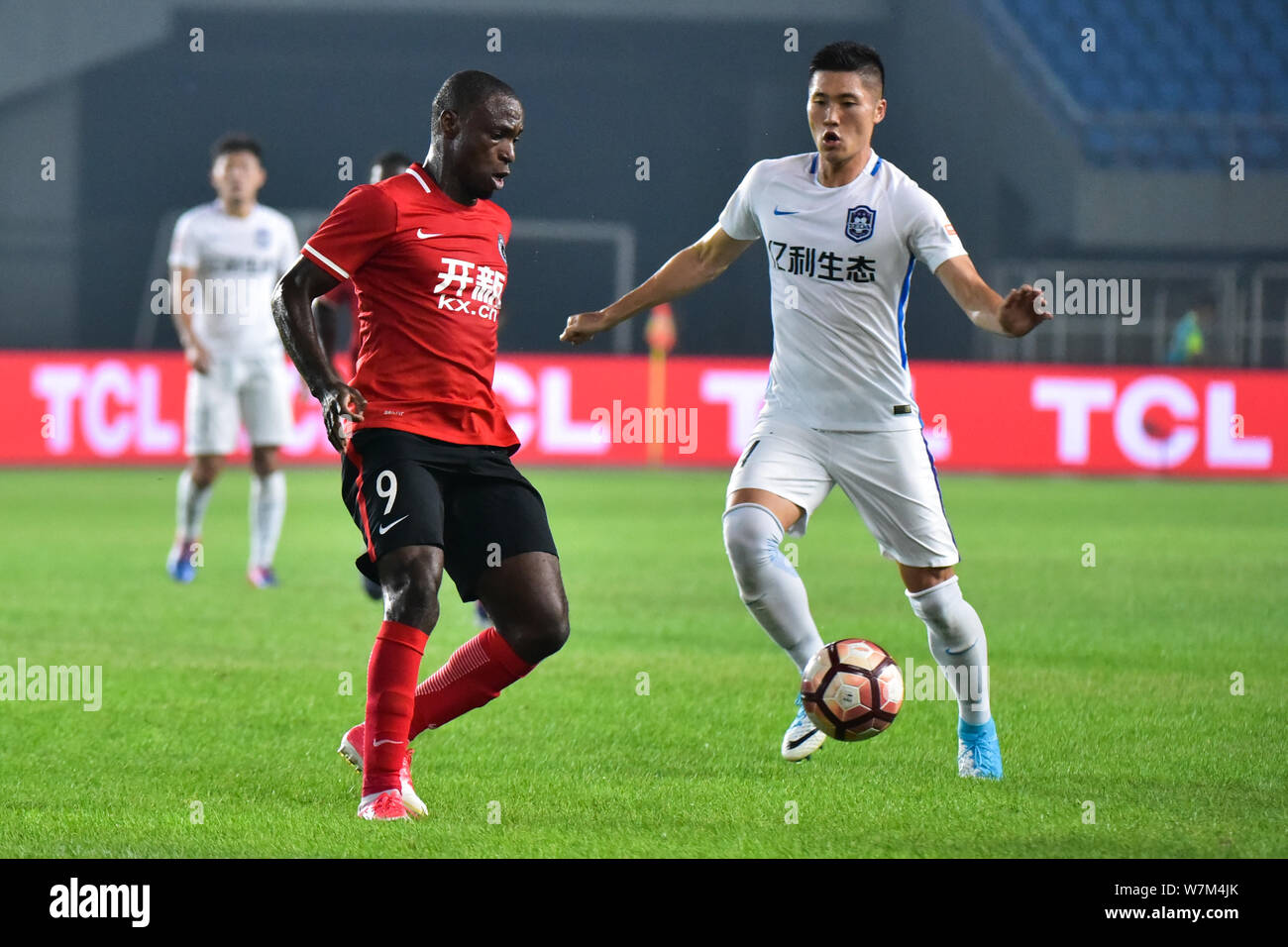 Nigerian football player Anthony Ujah, left, of Liaoning Whowin, challenges South Korean football player Hwang Seok-ho of Tianjin TEDA in their 23rd r Stock Photo