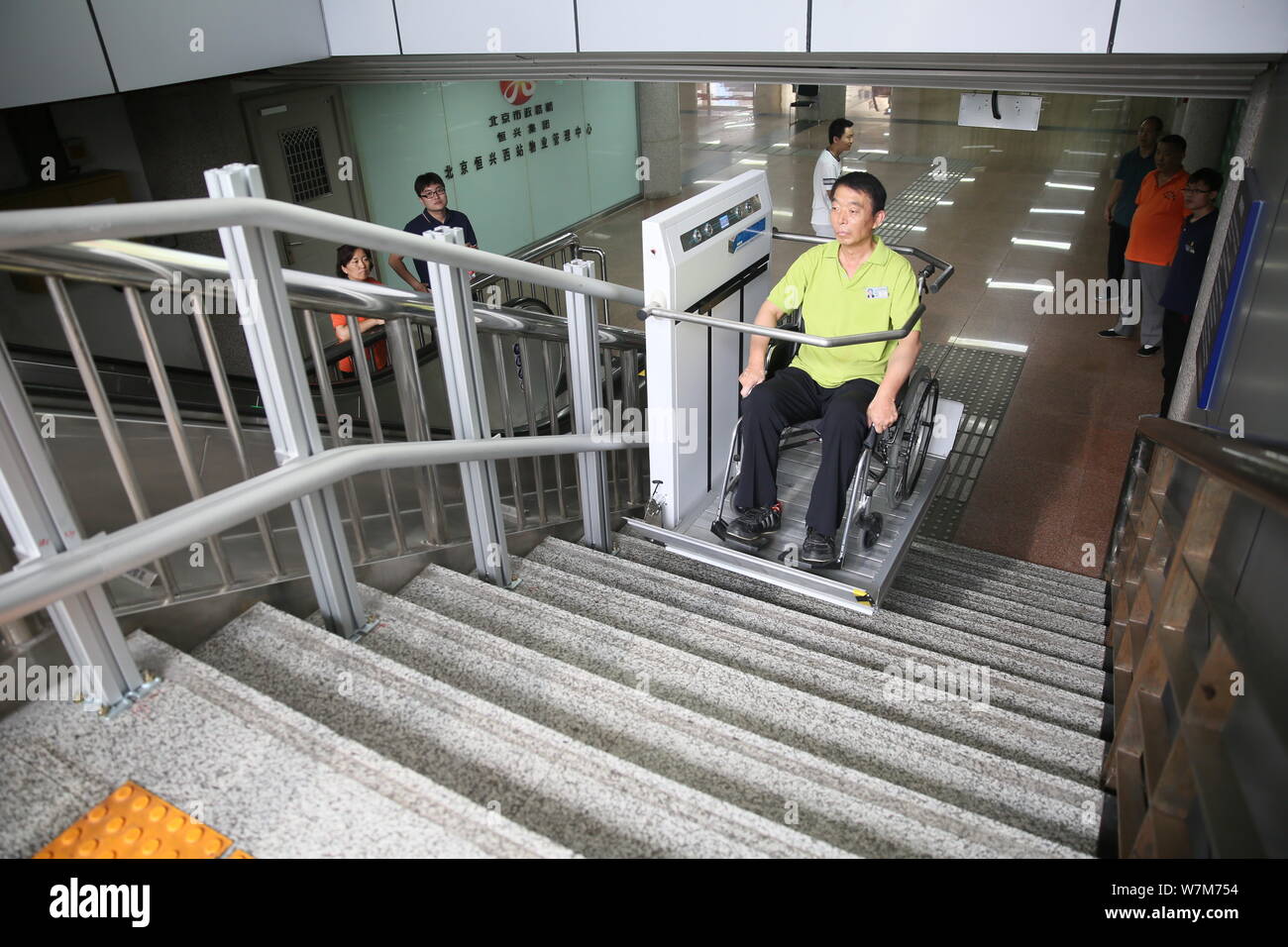 A disabled passenger uses the wheelchair lift platform designed for