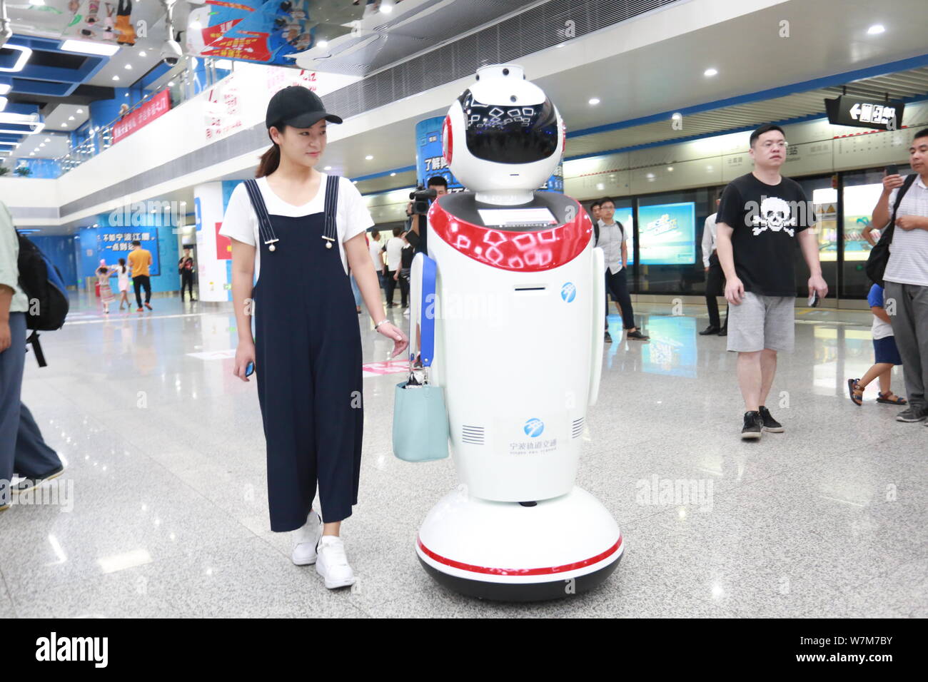 A smart robot helps a passenger carry a handbag at Ningbo Railway Station on Metro line 2 in Ningbo city, east China's Zhejiang province, 7 August 201 Stock Photo