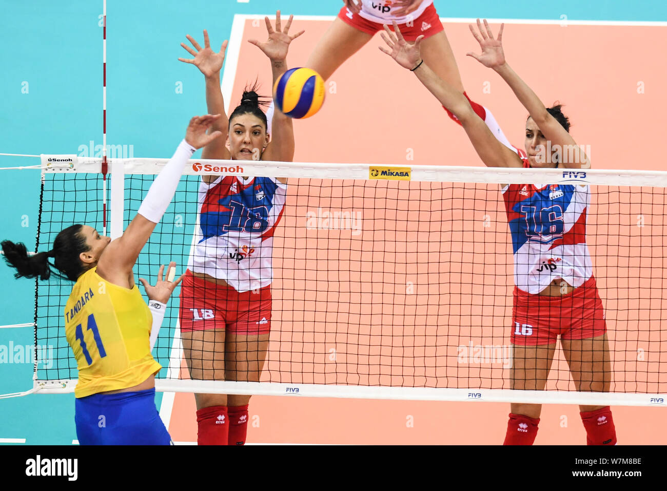 Tandara Caixeta of Brazil spikes against Tijana Boskovic and Milena Rasic of Serbia during their match of the FIVB Volleyball World Grand Prix Finals Stock Photo