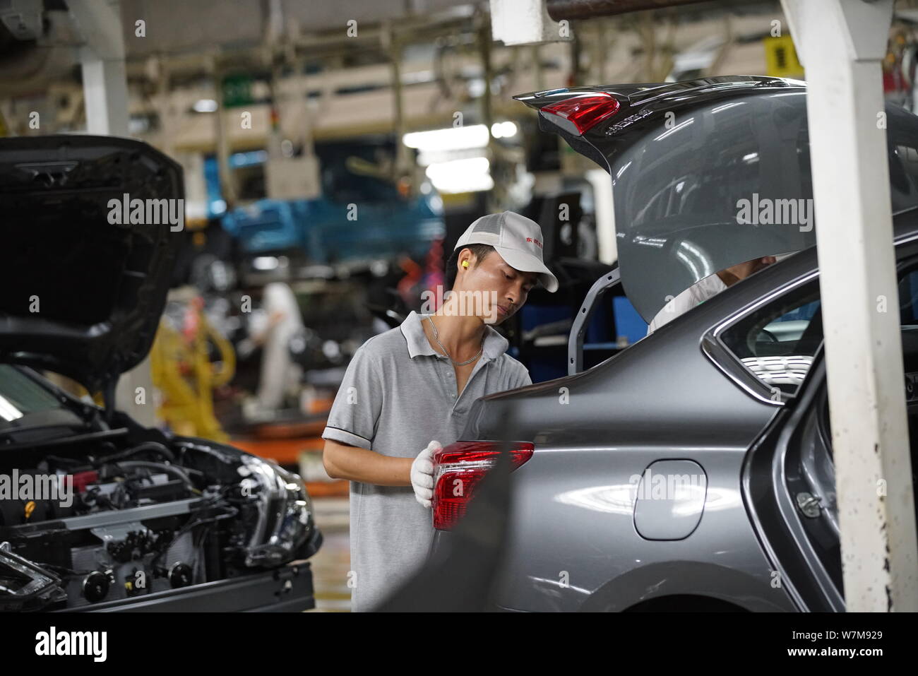 --FILE--A Chinese worker assembles a car on the assembly line at an ...