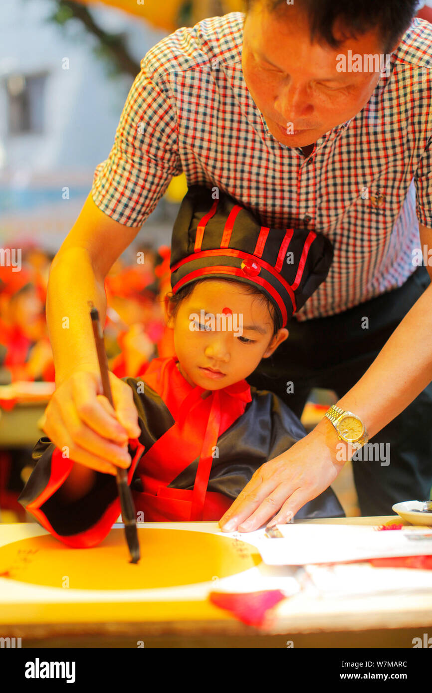 A new firstgrader learns to write the Chinese character "Ren," meaning