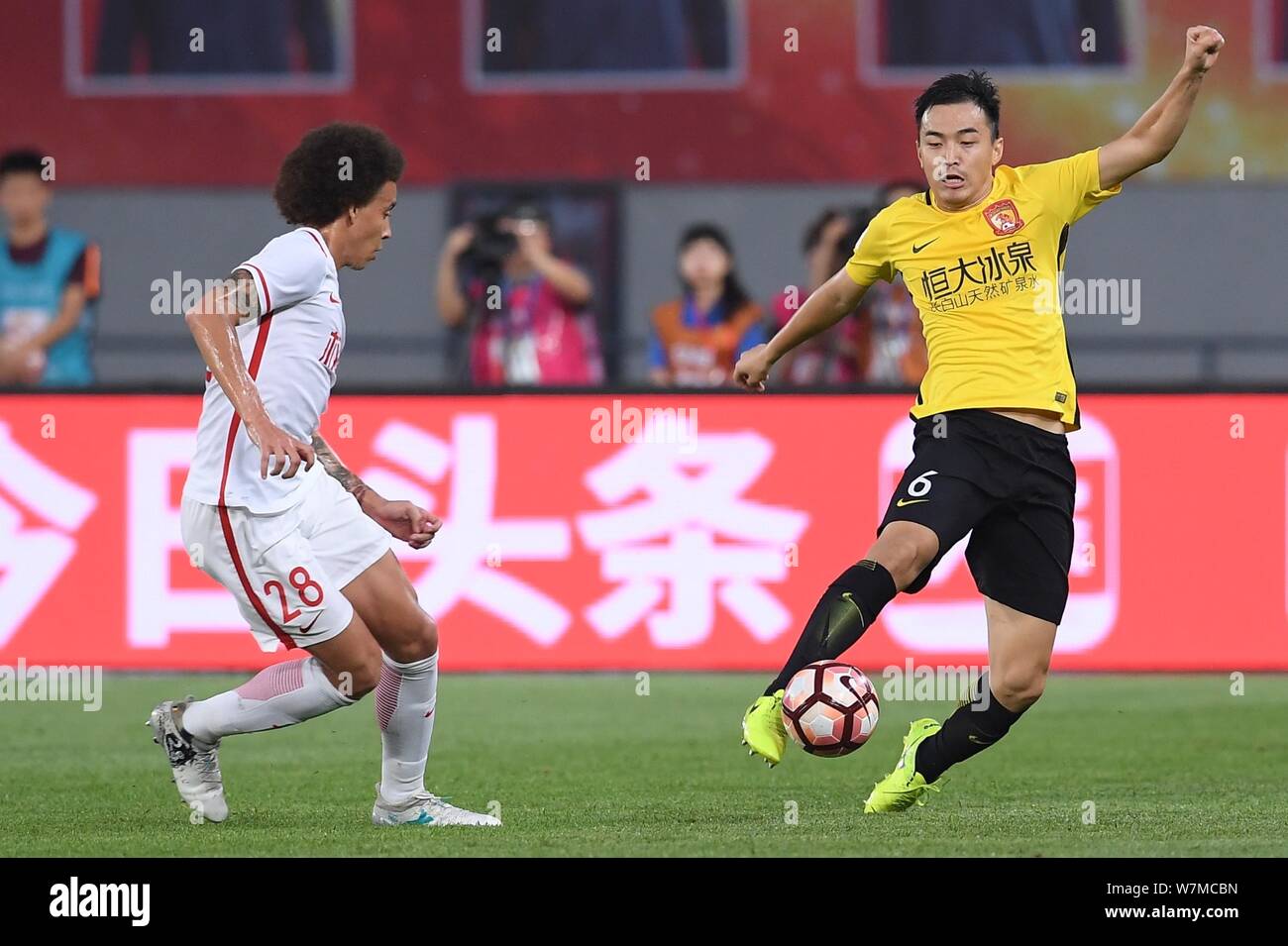 Belgian football player Axel Witsel, left, of Tianjin Quanjian challenges a player of Guangzhou Evergrande in their 15th round match during the 2017 C Stock Photo