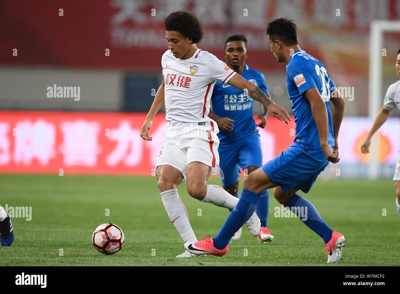 Belgian football player Axel Witsel, left, of Tianjin Quanjian, challenges a player of Guangzhou R&F in their 16th round match during the 2017 Chinese Stock Photo