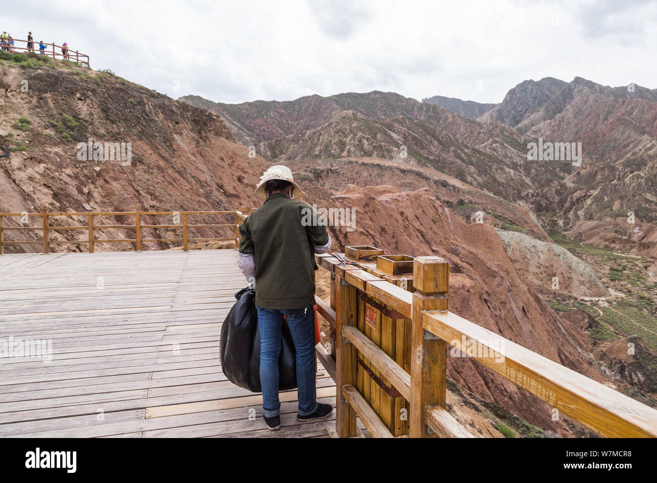 49-year-old Chinese cleaner surnamed Hu cleans up garbage on a mountain at the Zhangye Danxia Landform Geological Park in Zhangye city, northwest Chin Stock Photo