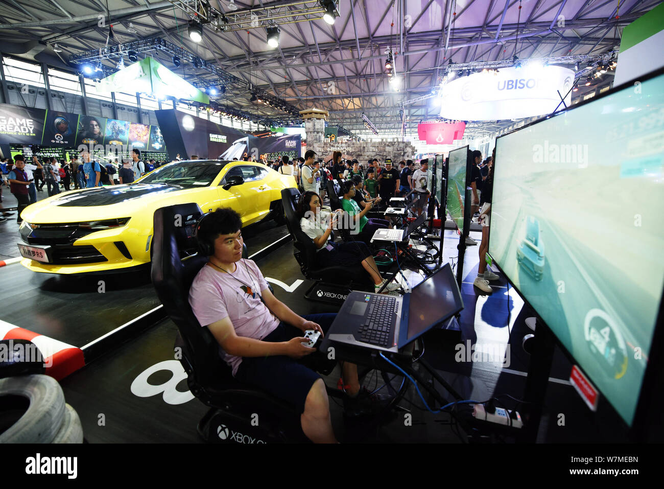 Visitors play racing car electronic games on Microsoft's Xbox One game consoles during the 15th China Digital Entertainment Expo, also known as ChinaJ Stock Photo