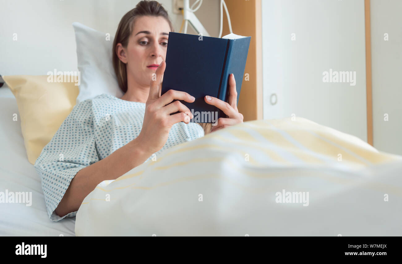 Woman in hospital bed reading the bible Stock Photo