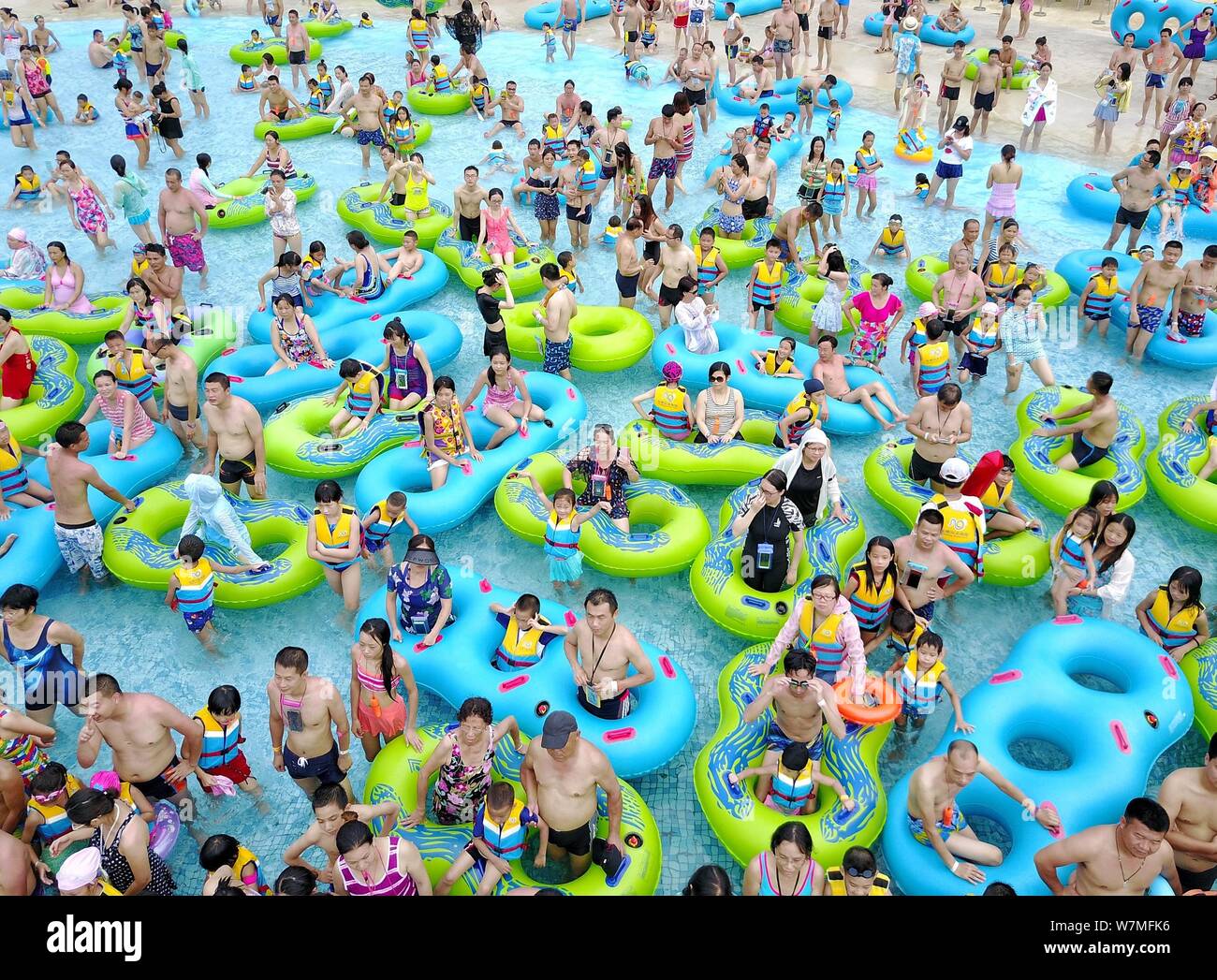 Chinese holidaymakers crowd a swimming pool at a water park on a