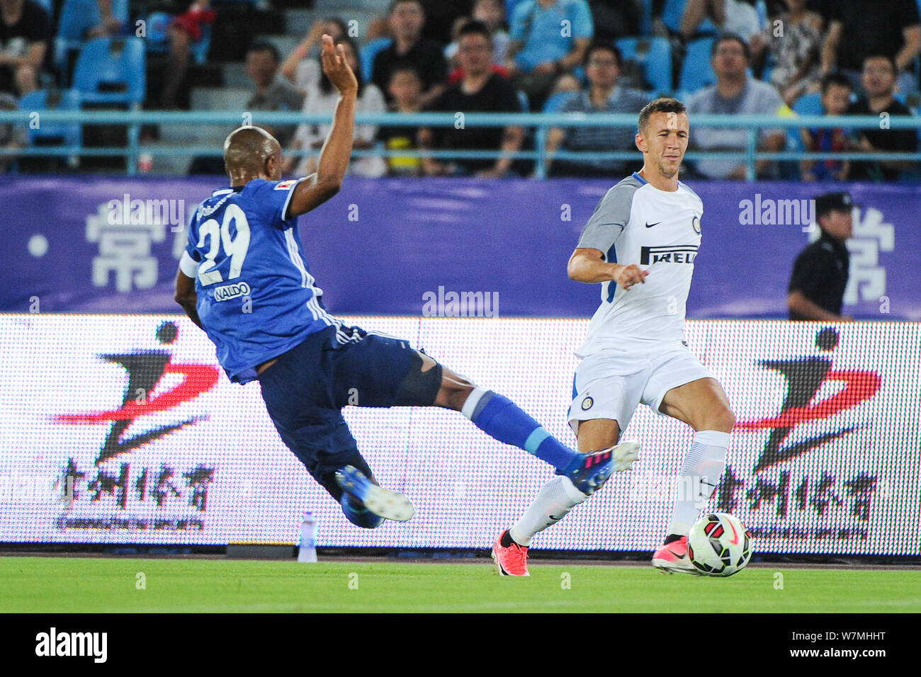 Croatian football player Ivan Perisic, right, of Inter Milan kicks the ball to make a pass against Brazilian-German football player Naldo of FC Schalk Stock Photo