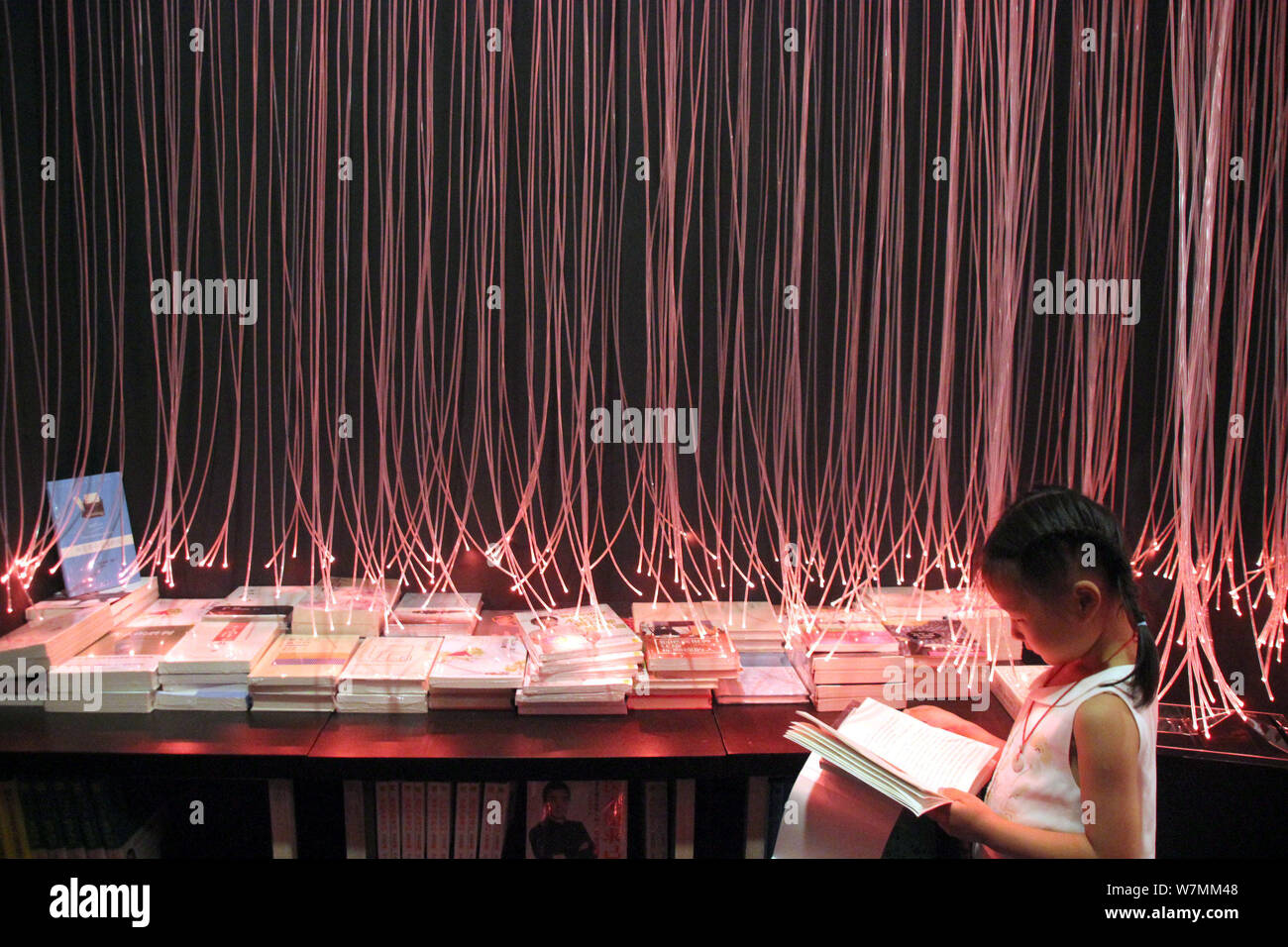 A visitor reads books at the Zhongshuge Bookstore in Suzhou city, east China's Jiangsu province, 24 July 2017.   Visitors flocked to branch of Zhongsh Stock Photo