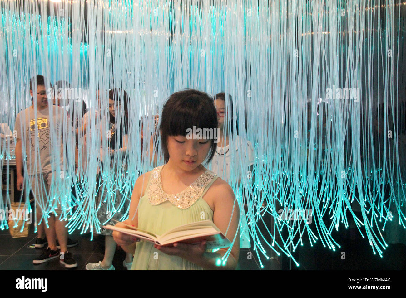 A visitor reads books at the Zhongshuge Bookstore in Suzhou city, east China's Jiangsu province, 24 July 2017.   Visitors flocked to branch of Zhongsh Stock Photo