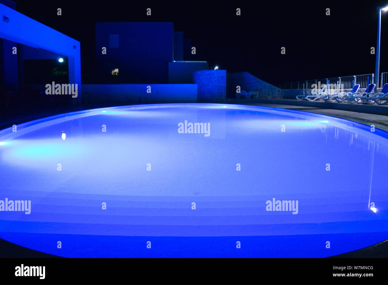 Illuminated empty swimming pool, night photography, blue light Stock Photo