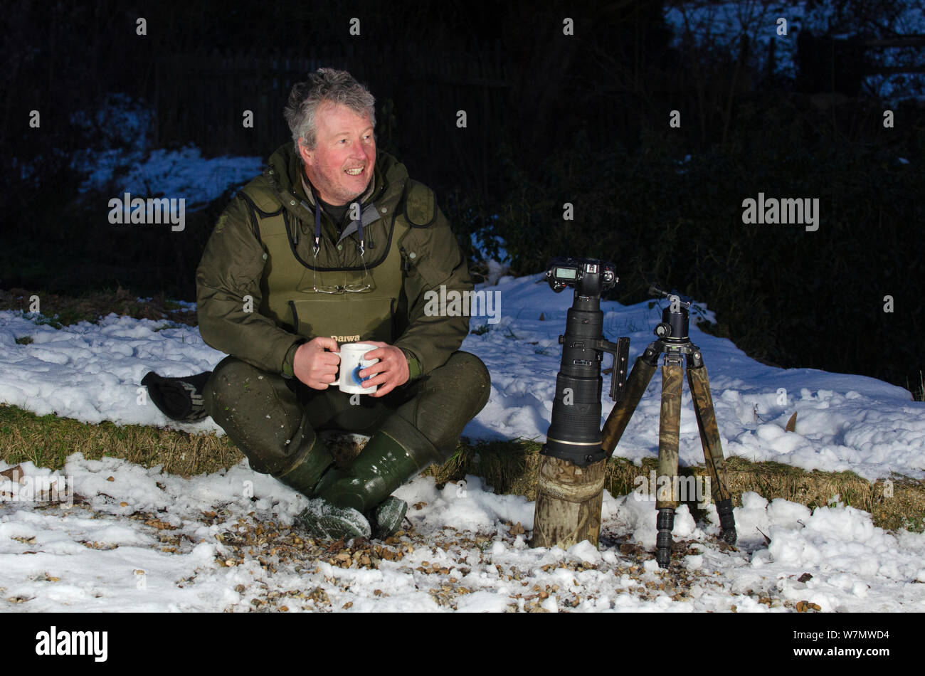 2020VISION Photographer Terry Whittaker drinking tea whilst having a break from photographing water voles (Arvicola terrestris), Kent, England, UK, February 2012. Model released. Stock Photo