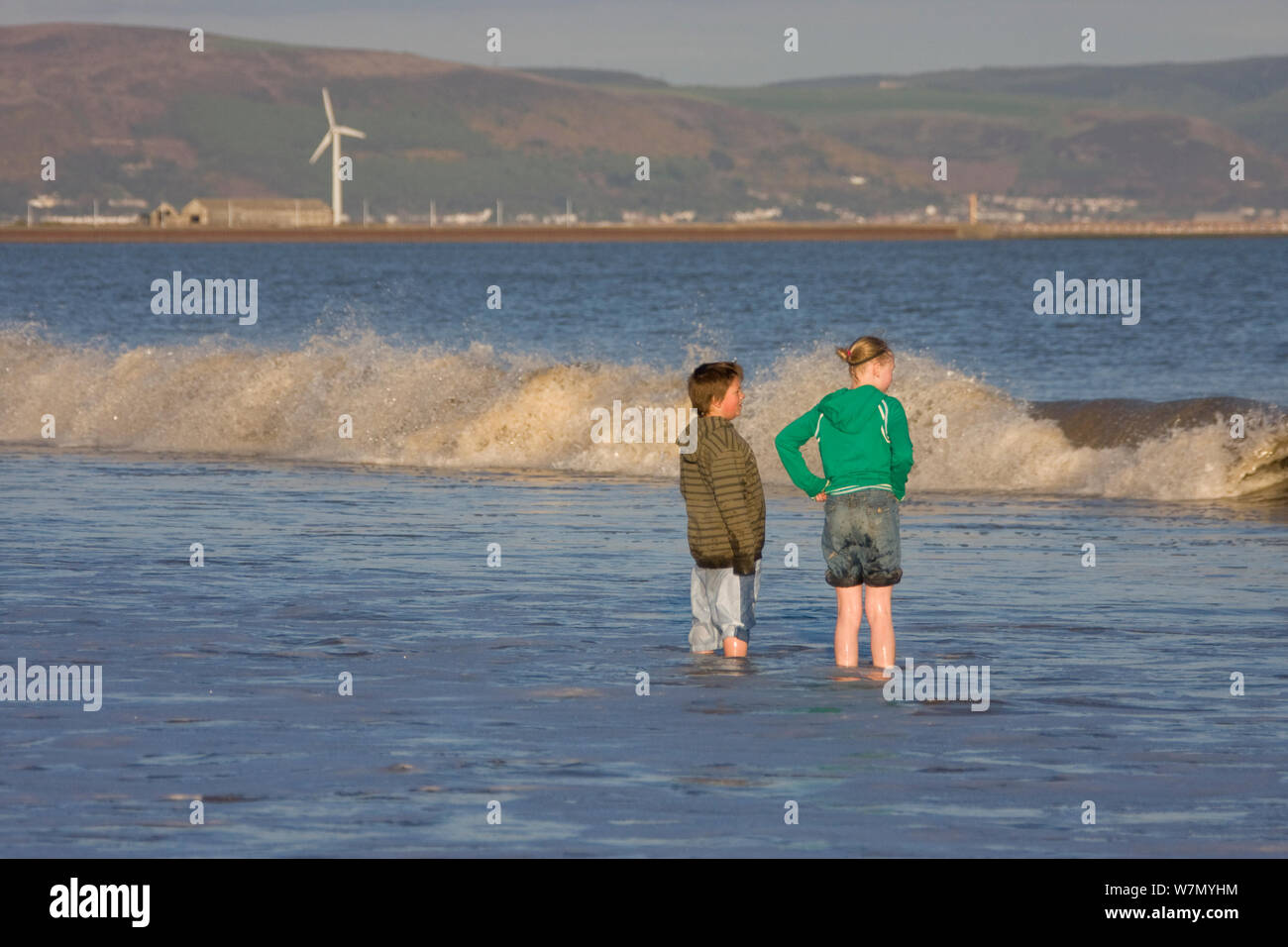 Children standing in shallows of sea, Swansea Bay, Wales, UK 2009 No MR so not sent to website Stock Photo