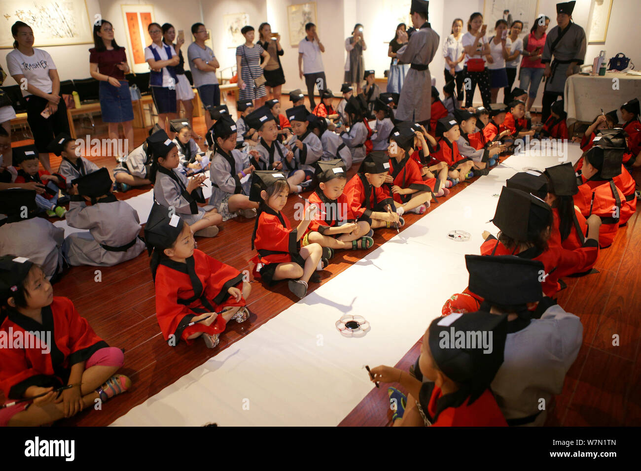 Students learn to write the Chinese character "Ren," meaning "Human" in