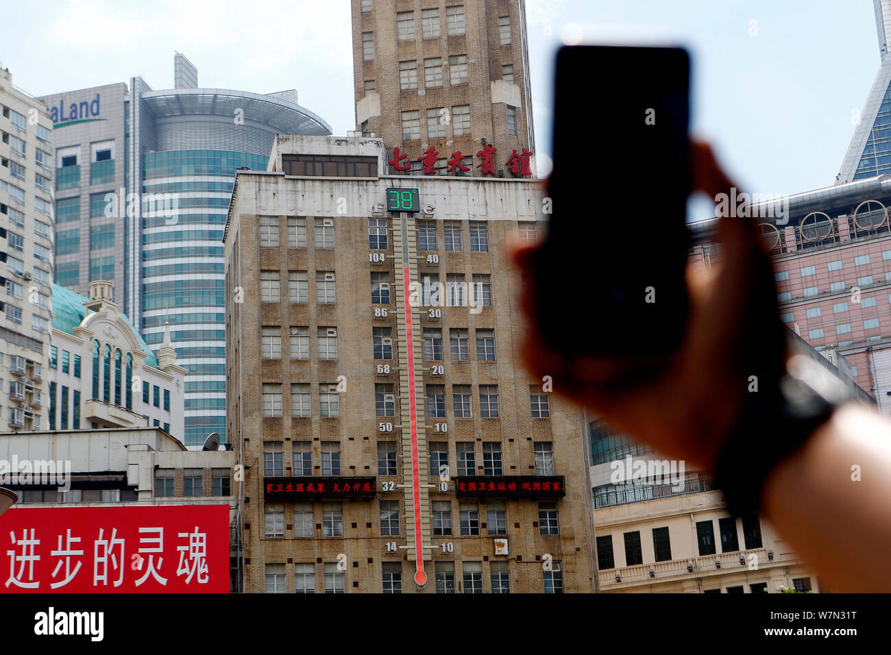 A huge thermometer on a building shows the current temperature reaching 38 degrees Celsius on a scorching day in Shanghai, China, 12 July 2017. Stock Photo