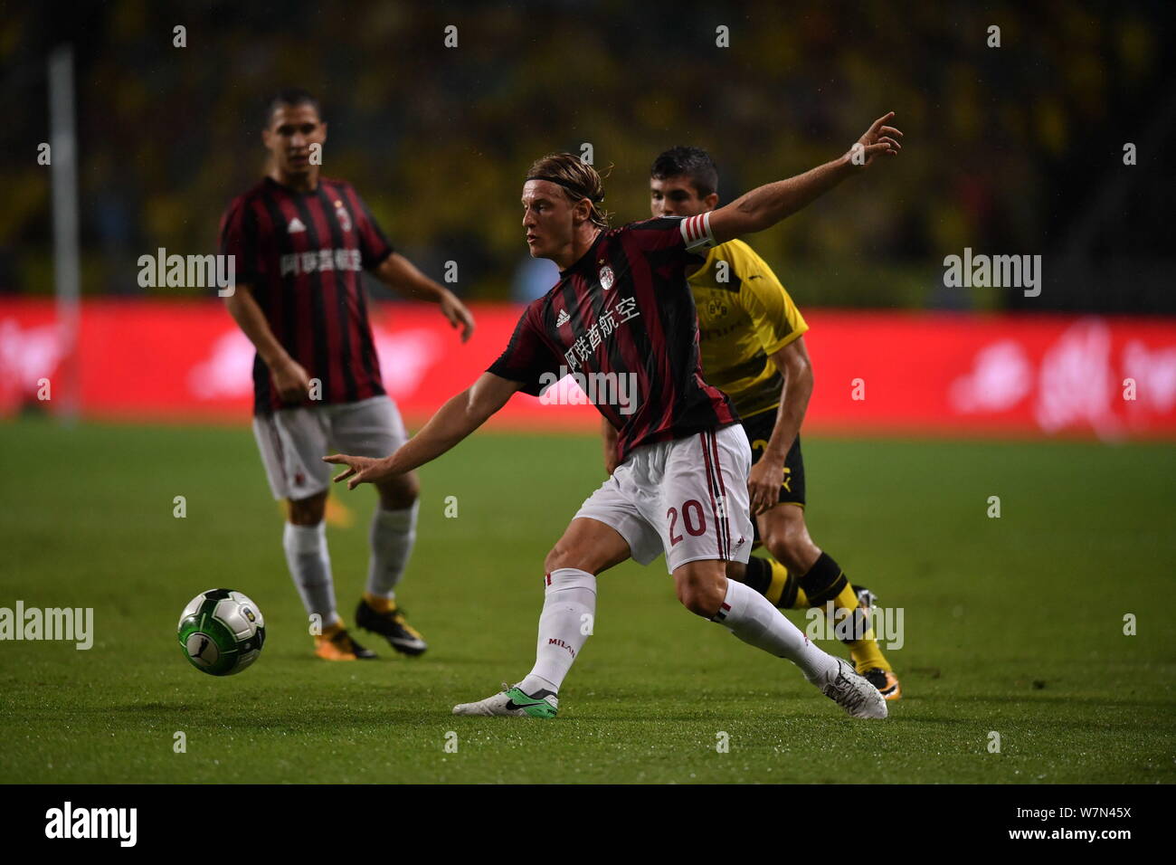 Italian football player Ignazio Abate, front, of AC Milan,  challenges a player of Borussia Dortmund during the Guangzhou match of the 2017 Internatio Stock Photo