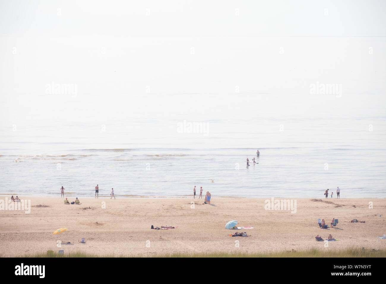 Egmond aan Zee, Netherlands - bathing people on the beach in the glistening sun (high key exposure) Stock Photo