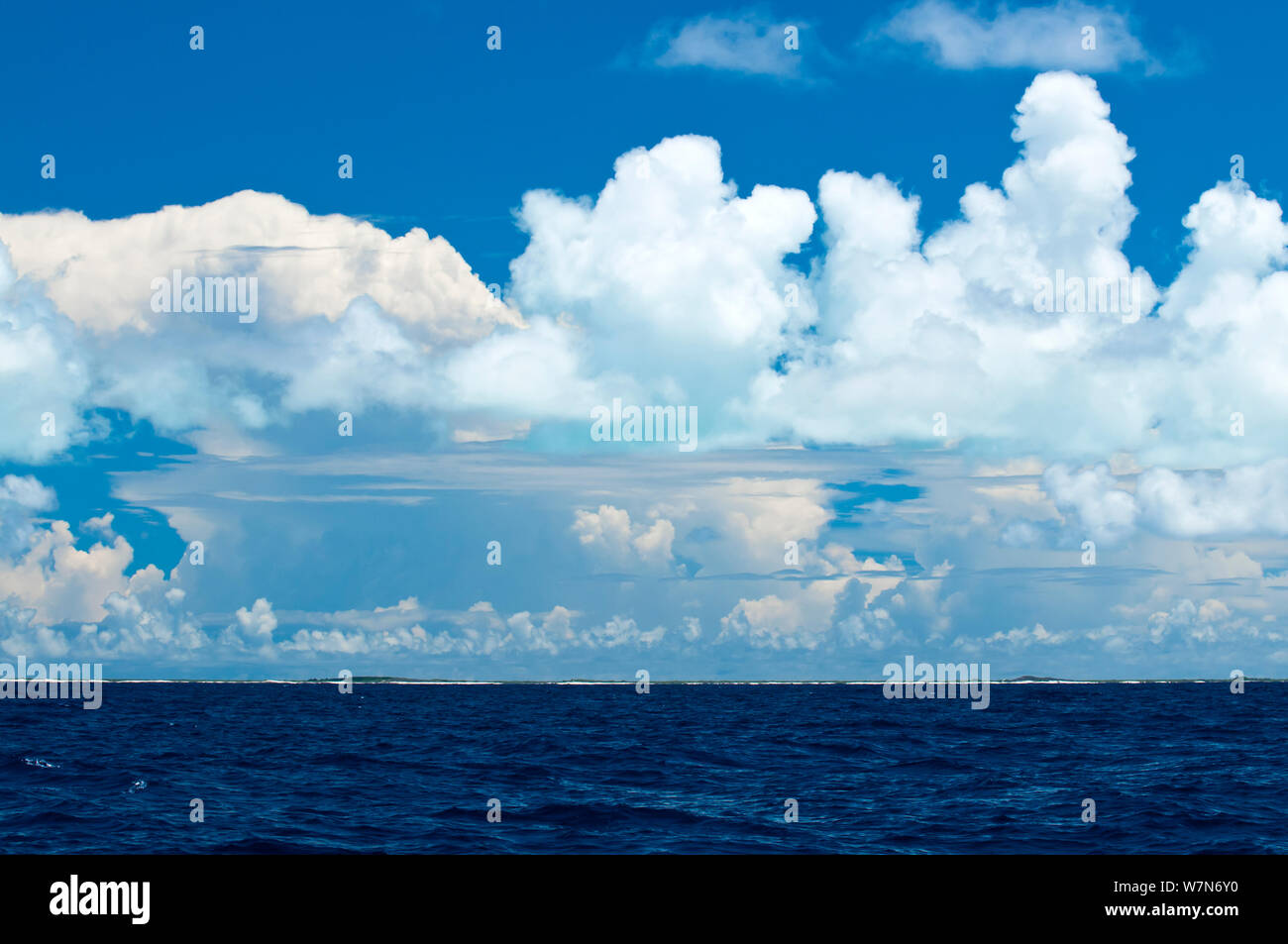 Lagoon reflects a green glow on to the clouds above Aldabra Atoll, Seychelles, Indian Ocean 2008 Stock Photo