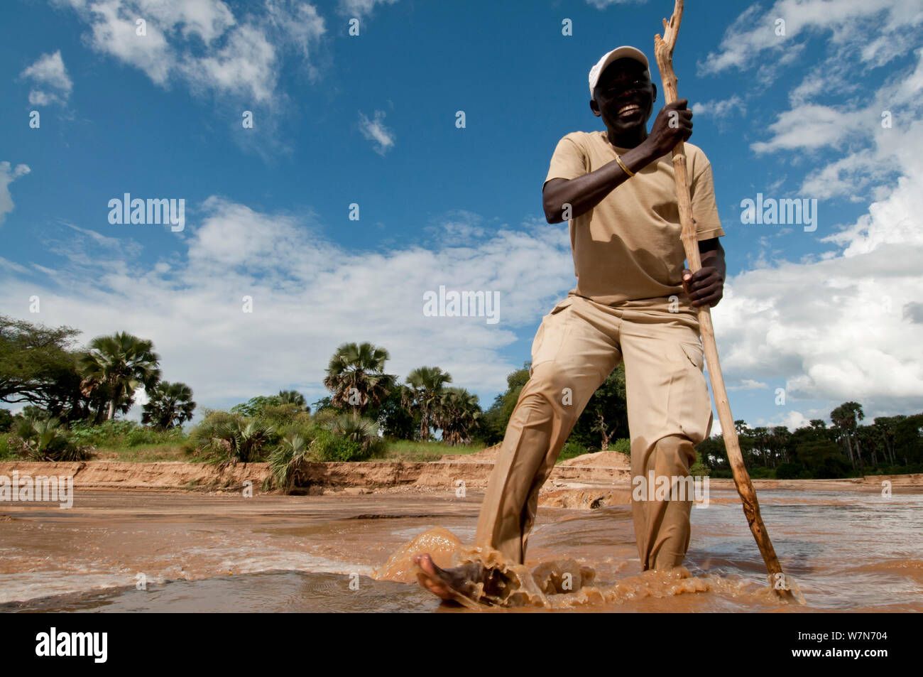 Guide from Apoka lodge tests the water level of the Kidepo River, Uganda, East Africa Stock Photo