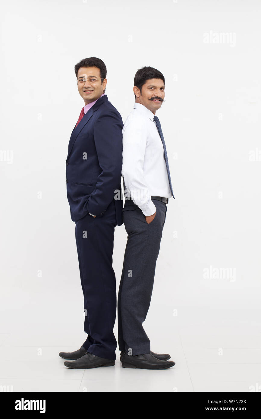 Two business executives standing back to back Stock Photo