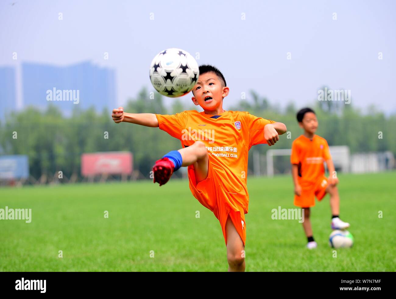 Young Chinese kids play soccer in an outdoor football pitch at the "Li