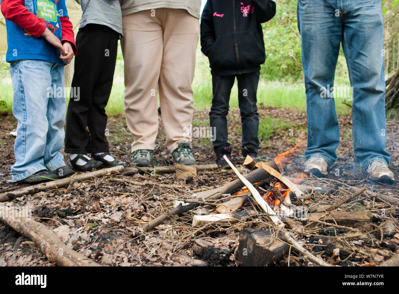 Five people standing next to a small fire on a bushcraft day, Palacerigg Country Park, Cumbernauld, North Lanarkshire, Scotland, UK, July  2011 Stock Photo