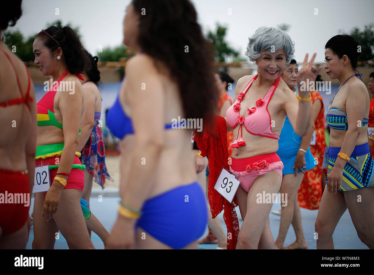 Elderly Chinese women dressed in bikini pose during a middle-aged