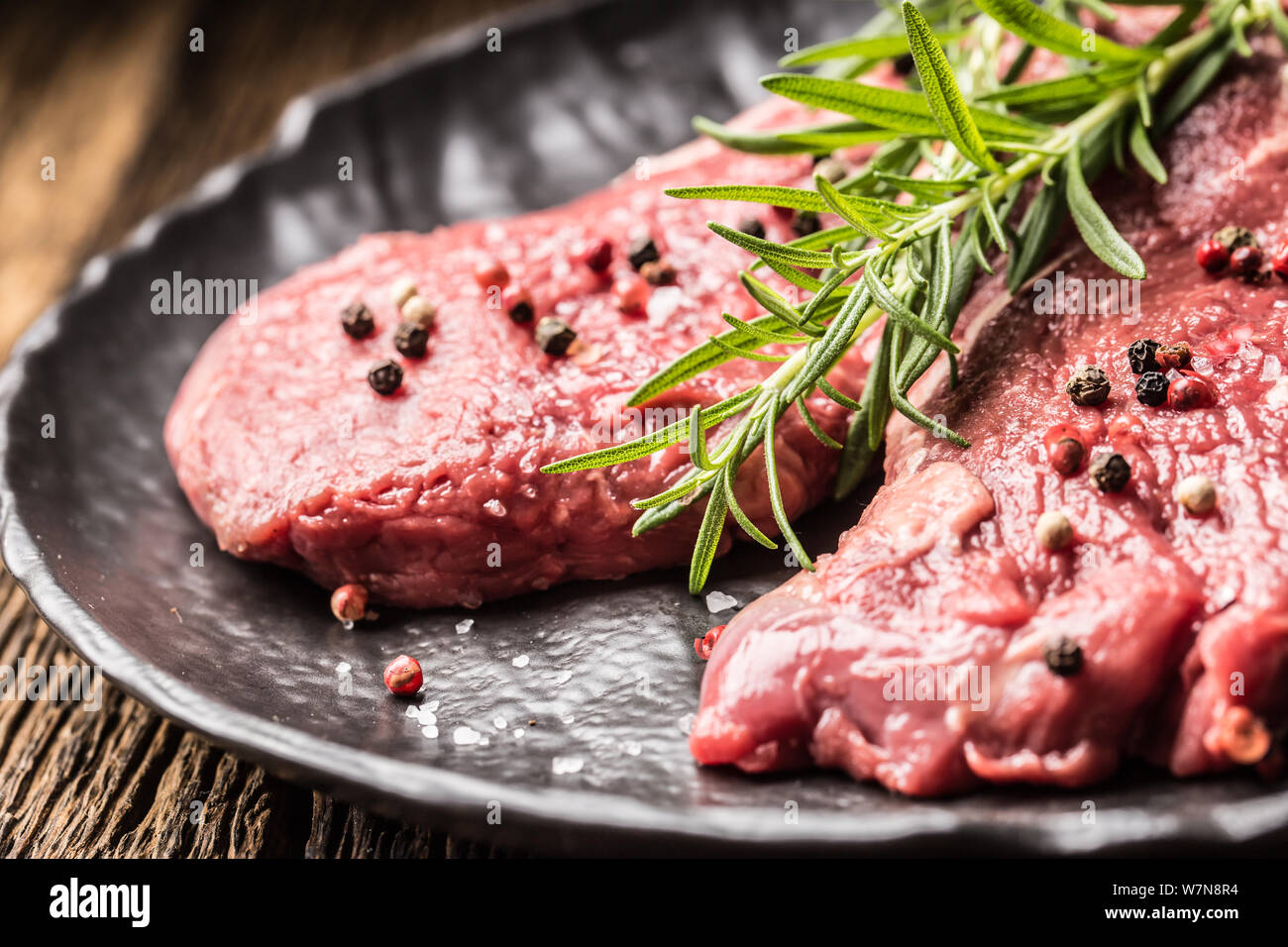 Beef meeat Rib-Eye steak wit rosemary salt and pepper on black plate Stock Photo