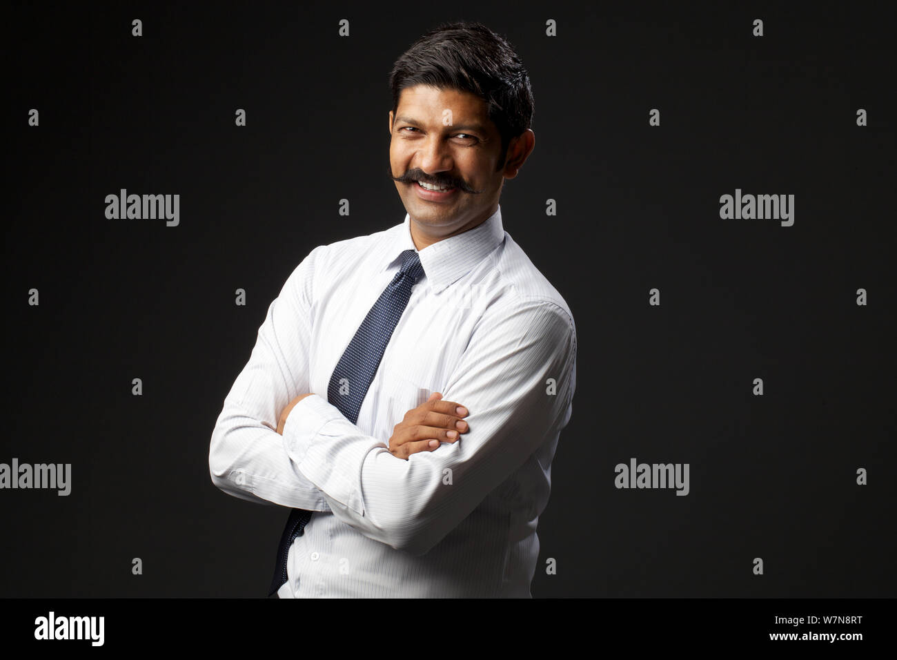 Businessman smiling with his arms crossed Stock Photo - Alamy