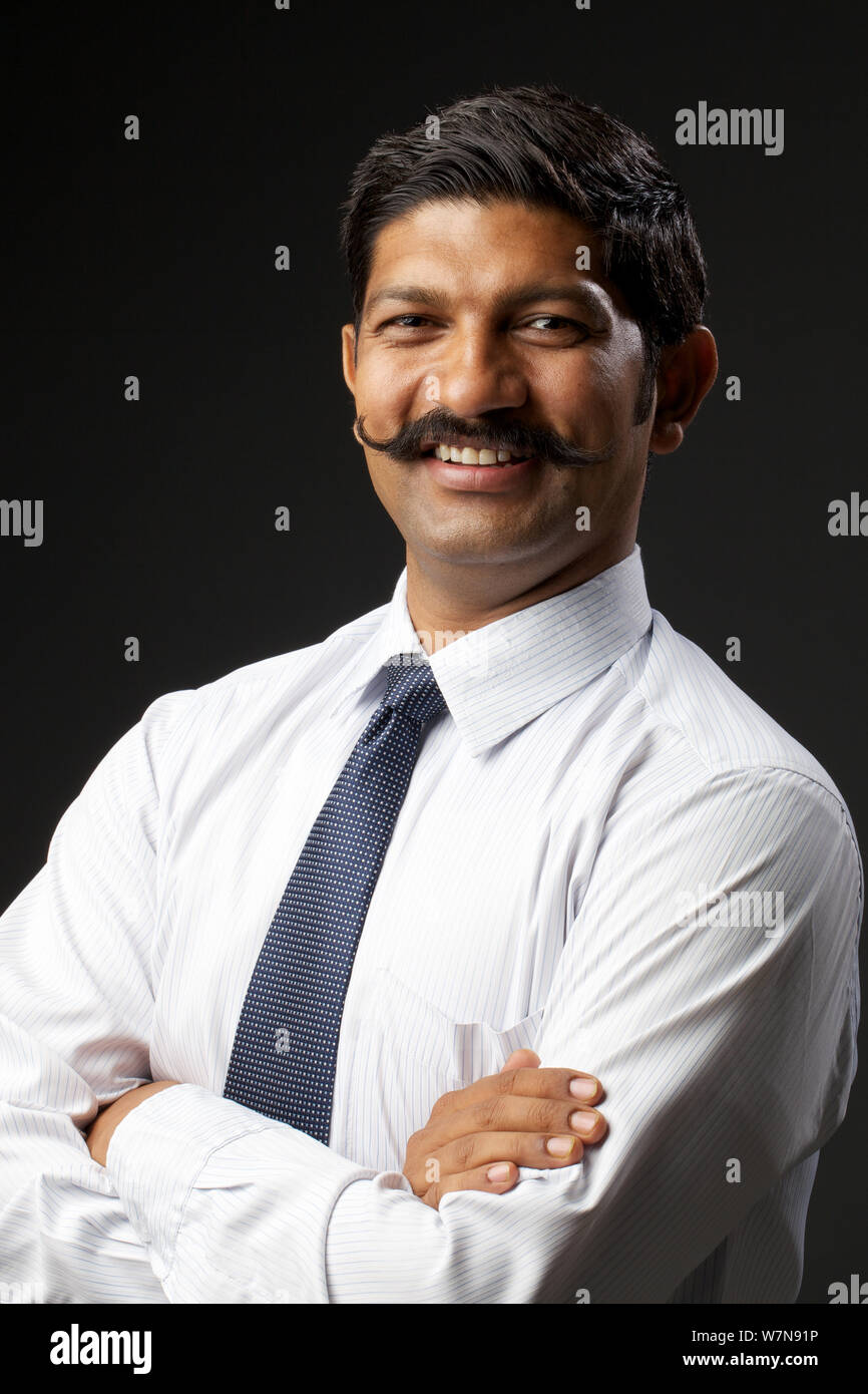 Businessman smiling with his arms crossed Stock Photo - Alamy